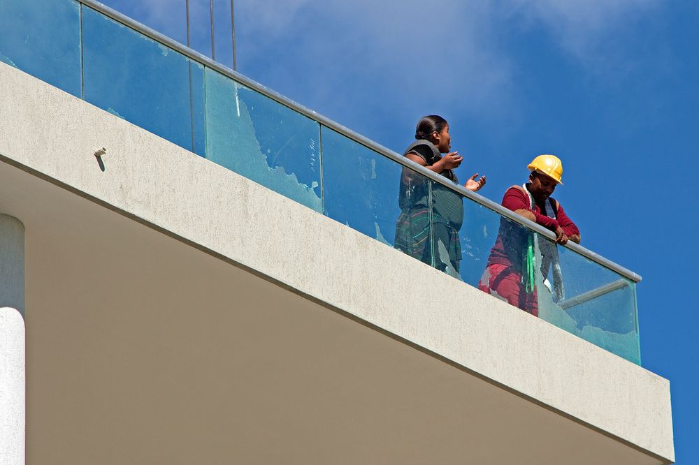 Builders on the balcony of a finished modern building